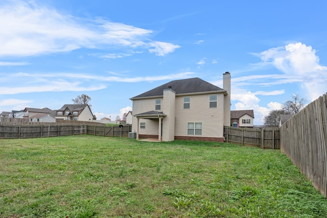 back of property with cooling unit and a yard