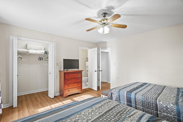 bedroom with hardwood / wood-style flooring, ceiling fan, a textured ceiling, connected bathroom, and a closet