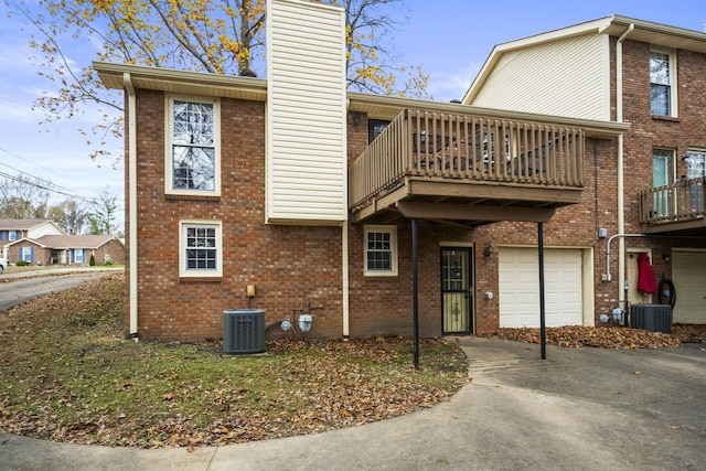 exterior space featuring a balcony, a garage, and central AC unit