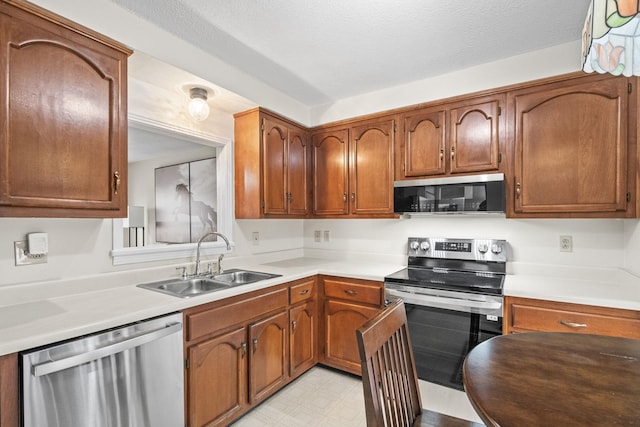 kitchen with sink, stainless steel appliances, and a textured ceiling