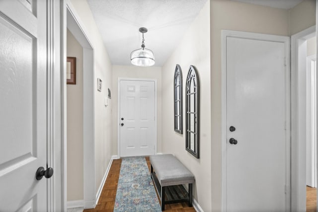 doorway to outside with a notable chandelier, dark hardwood / wood-style flooring, and a textured ceiling