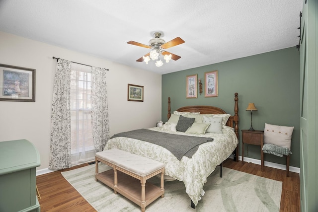 bedroom featuring a textured ceiling, ceiling fan, and dark wood-type flooring