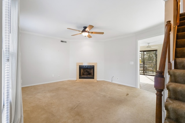 living room featuring light carpet, a tile fireplace, crown molding, and ceiling fan