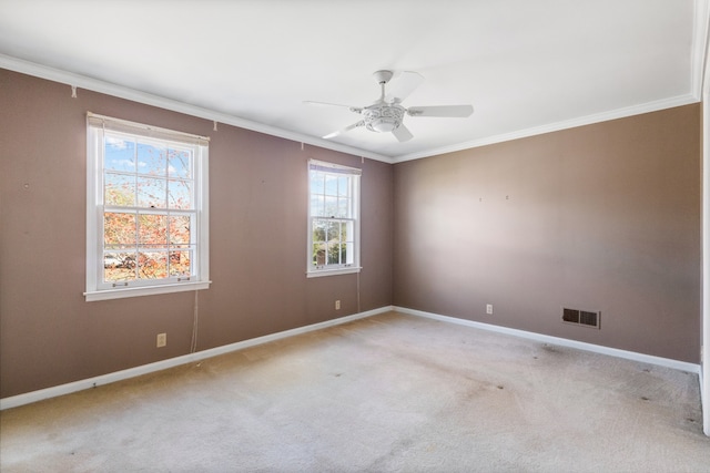 carpeted spare room featuring ornamental molding, ceiling fan, and a healthy amount of sunlight