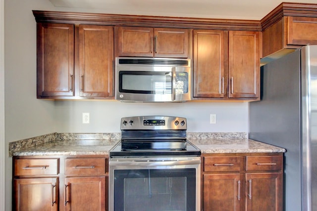 kitchen with appliances with stainless steel finishes and light stone counters