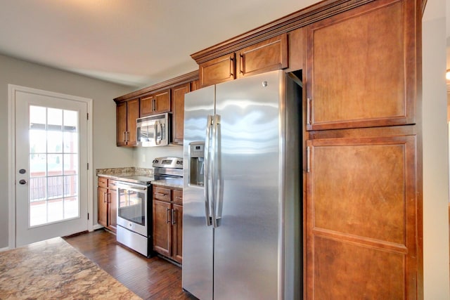 kitchen with dark hardwood / wood-style floors, plenty of natural light, light stone counters, and stainless steel appliances