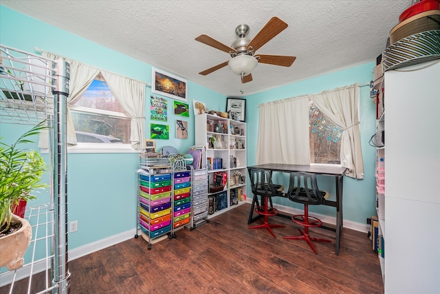 recreation room featuring a textured ceiling, dark hardwood / wood-style flooring, and ceiling fan