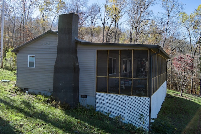 view of property exterior featuring a sunroom and a yard