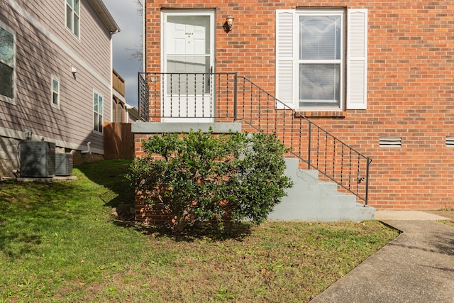 property entrance featuring a lawn and central AC