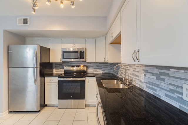 kitchen with white cabinetry, sink, stainless steel appliances, decorative backsplash, and light tile patterned floors