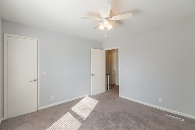 carpeted spare room featuring ceiling fan