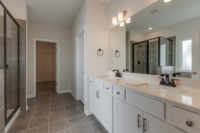 bathroom with vanity, tile patterned floors, and a shower with door