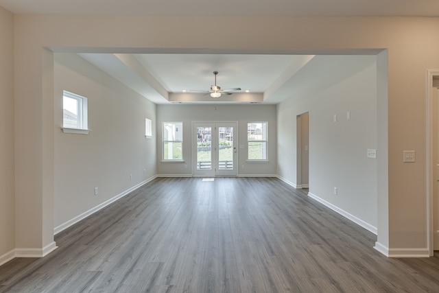 spare room with hardwood / wood-style flooring, ceiling fan, and a raised ceiling