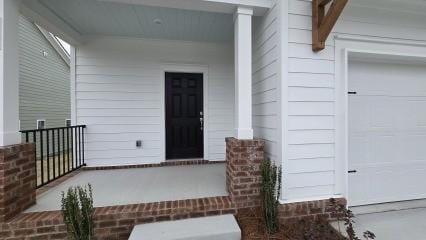 doorway to property featuring a garage and covered porch