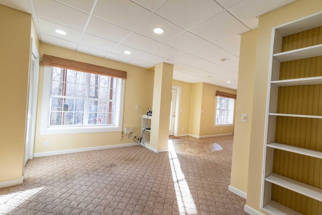 carpeted empty room with a paneled ceiling