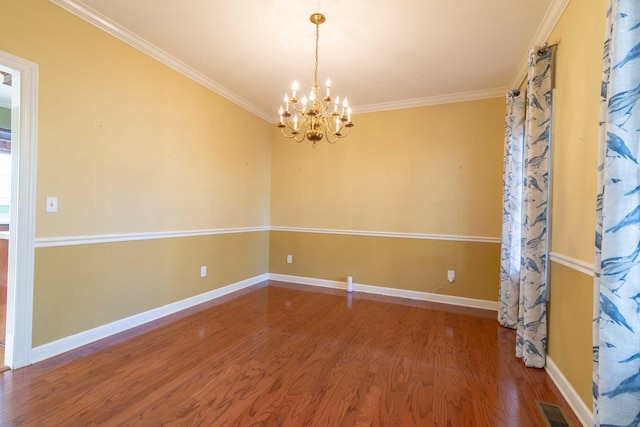 spare room with hardwood / wood-style floors, ornamental molding, and a chandelier