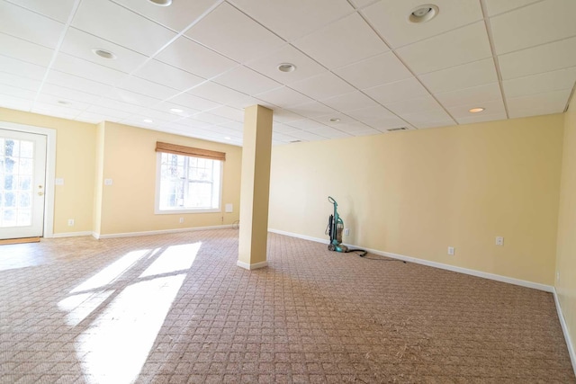 basement with a paneled ceiling and carpet floors