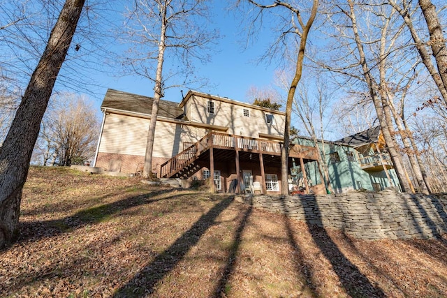 rear view of house with a lawn and a wooden deck