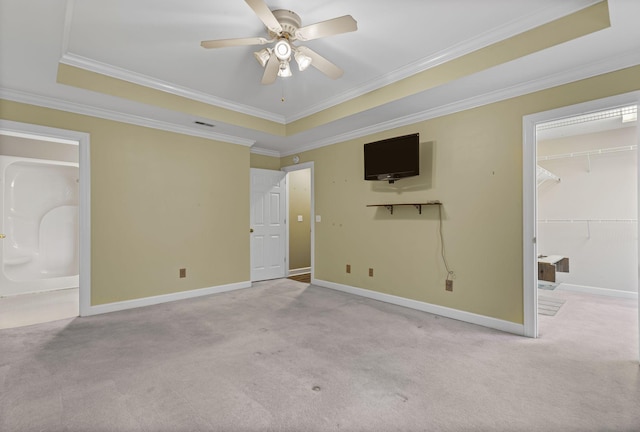 unfurnished bedroom with light carpet, ornamental molding, and a raised ceiling