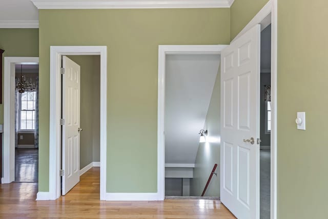 bedroom with crown molding, an inviting chandelier, and light hardwood / wood-style floors