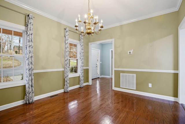 unfurnished dining area with hardwood / wood-style flooring, ornamental molding, and a chandelier