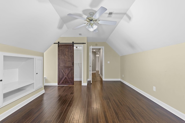 bonus room featuring a barn door, ceiling fan, lofted ceiling, and dark hardwood / wood-style floors