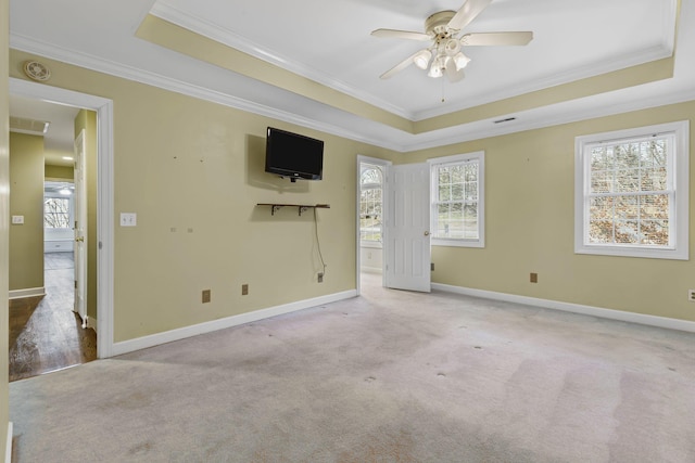 unfurnished room featuring crown molding, ceiling fan, a raised ceiling, and light carpet