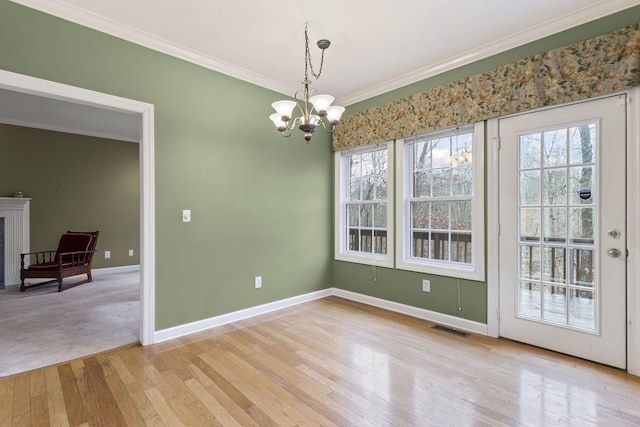 dining space with ornamental molding, a chandelier, and light hardwood / wood-style floors