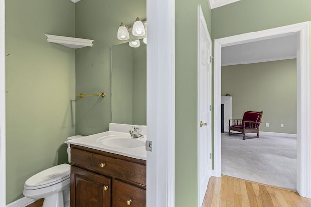 bathroom with crown molding, vanity, toilet, and hardwood / wood-style floors