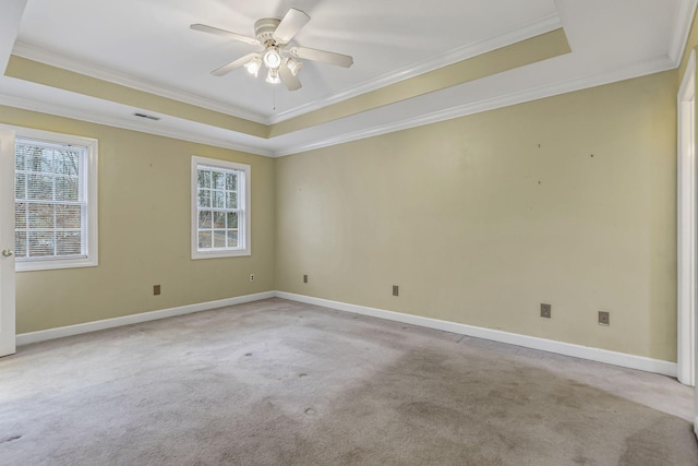 carpeted spare room featuring a raised ceiling, crown molding, and ceiling fan