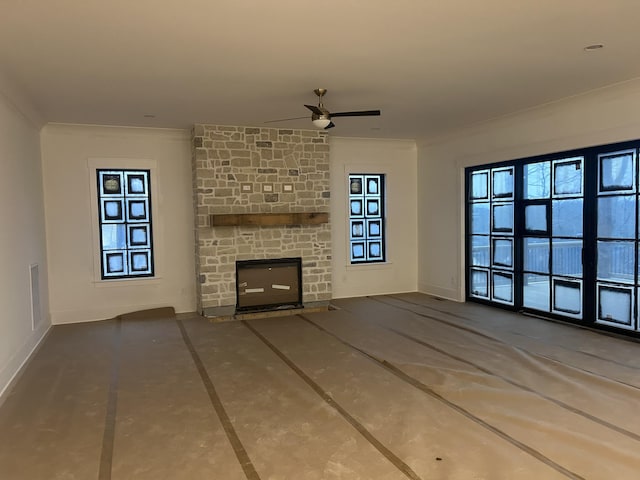 unfurnished living room with crown molding, a large fireplace, and ceiling fan