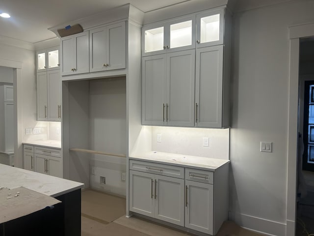 kitchen featuring light stone counters and white cabinets