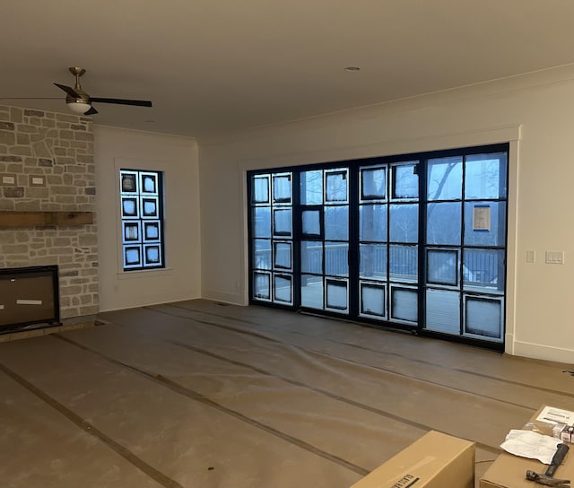 unfurnished living room featuring ceiling fan, ornamental molding, and a fireplace