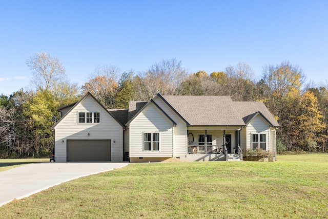 view of front of house featuring covered porch, a garage, and a front lawn