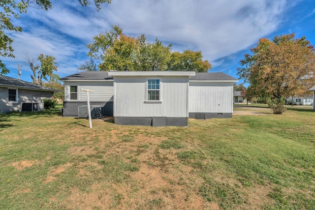 back of property with cooling unit and a yard