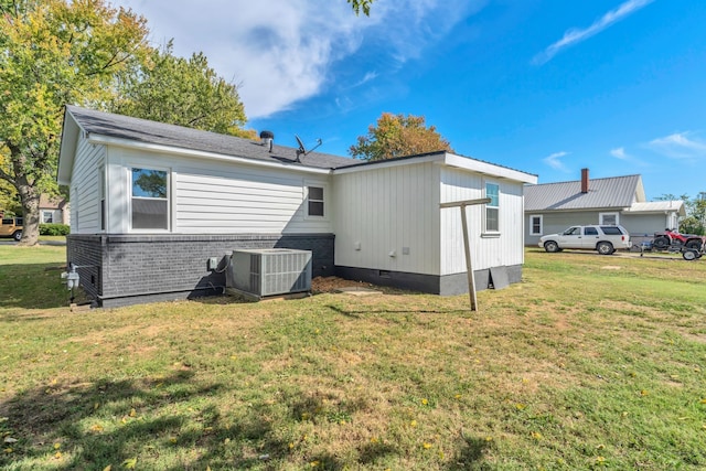 back of house featuring a lawn and cooling unit