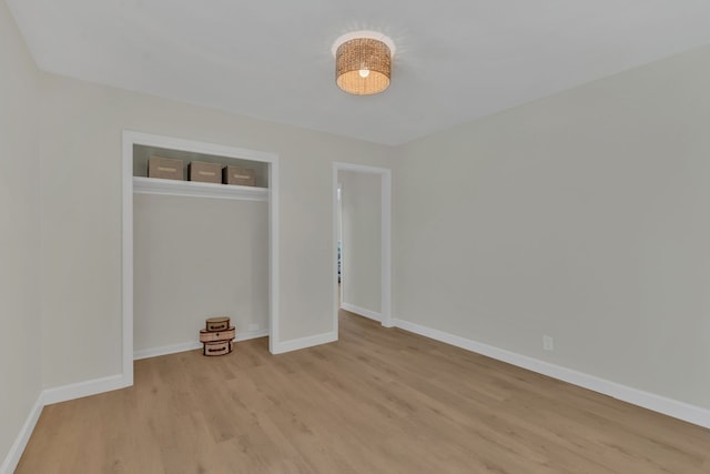 unfurnished bedroom featuring light wood-type flooring and a closet