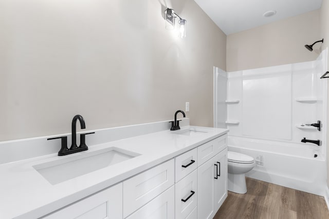 full bathroom with shower / tub combination, vanity, wood-type flooring, and toilet