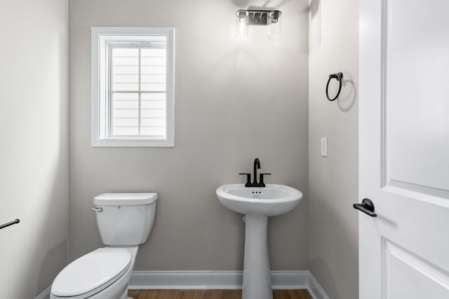 bathroom with hardwood / wood-style floors and toilet