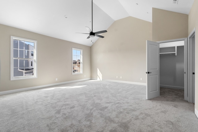 unfurnished bedroom with light carpet, a closet, high vaulted ceiling, and ceiling fan