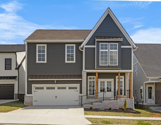 view of front of home featuring a porch, concrete driveway, metal roof, an attached garage, and a standing seam roof