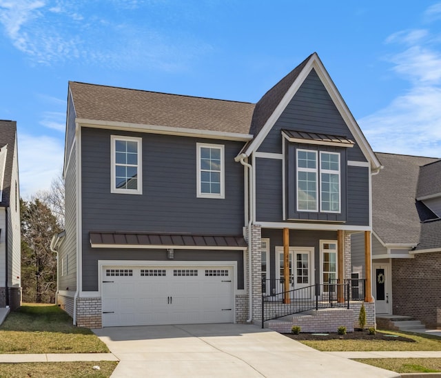 view of front of property with a standing seam roof, covered porch, a garage, and driveway