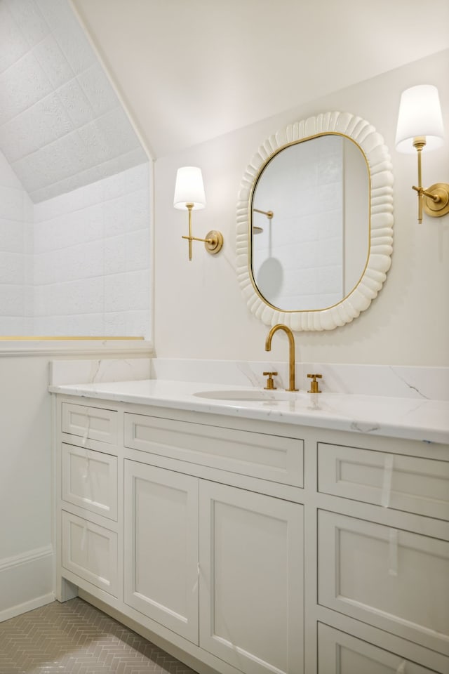 bathroom with vanity and lofted ceiling