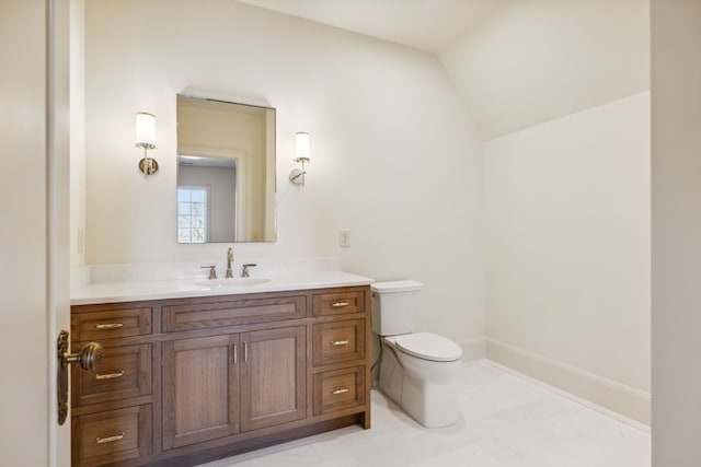 bathroom with vanity, toilet, and vaulted ceiling