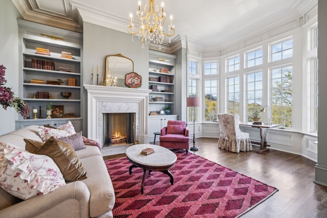 living area with built in shelves, a high end fireplace, dark wood-type flooring, and ornamental molding