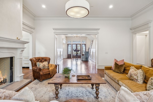 living room with crown molding, wood-type flooring, and a notable chandelier