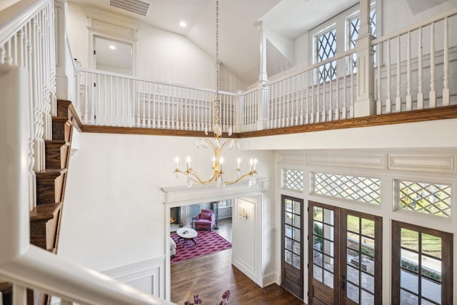 interior space featuring dark hardwood / wood-style floors, a chandelier, high vaulted ceiling, and french doors