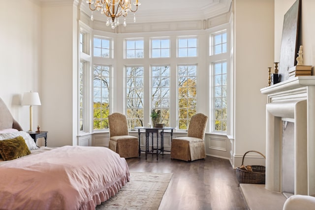 bedroom featuring a towering ceiling, hardwood / wood-style flooring, ornamental molding, and a notable chandelier