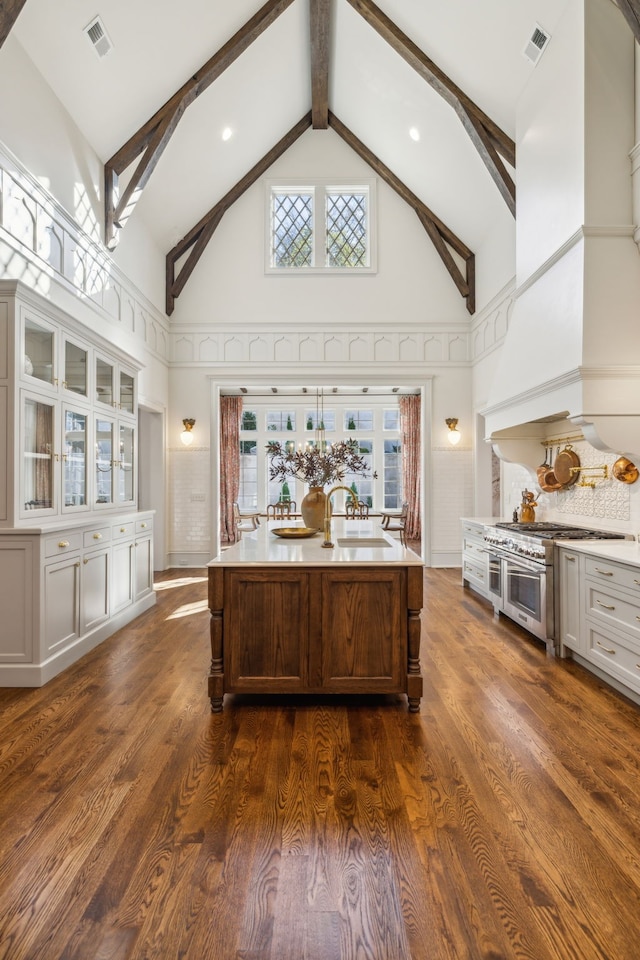 kitchen featuring high vaulted ceiling, custom exhaust hood, dark hardwood / wood-style floors, and a kitchen island