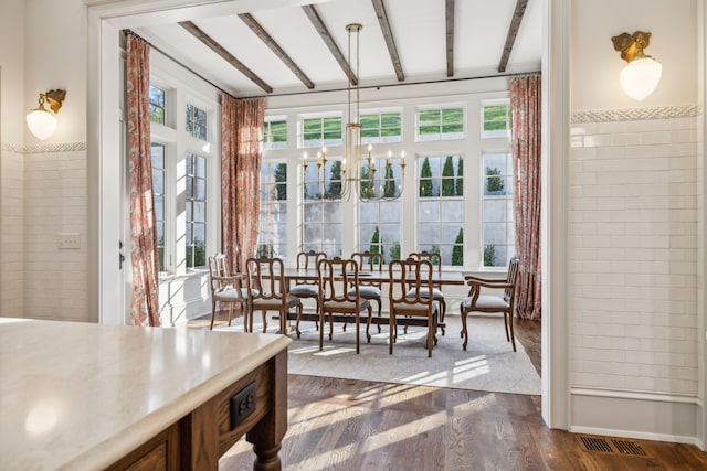 sunroom with beam ceiling and an inviting chandelier